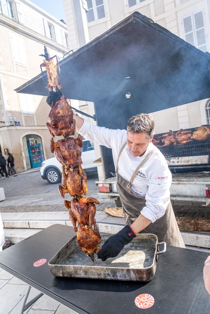 Le chef Thibault Lagoutte en train de faire rôtir des poulets sur la place de la cathédrale d'Auch